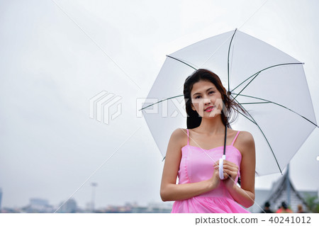 Holiday concept. Beautiful girl is holding umbrella on the beach Holiday concept. Beautiful girl is holding umbrella on the beach 40241012