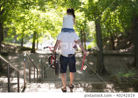 Father and daughter walking with a shoulder car Father and daughter walking with a shoulder car 40242819
