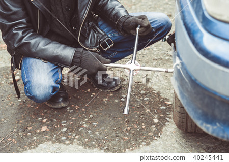 man changing wheel on a car man changing wheel on a car 40245441