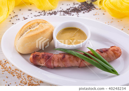 The fried sausage in bacon with feathers of green The fried sausage in bacon with feathers of green 40248234