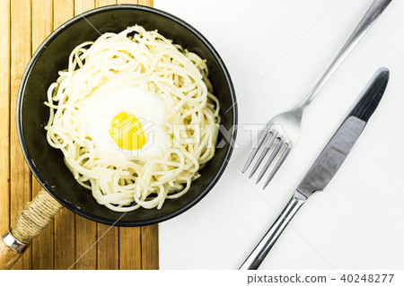 Fried egg and spaghetti in a black frying pan 40248277