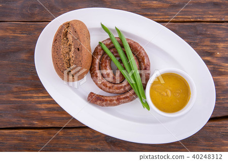 The sausage from beef fried on butter, on a dark w 40248312
