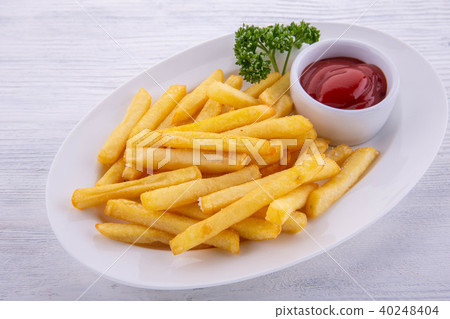 Ketchup with French fries, is served on a white pl Ketchup with French fries, is served on a white pl 40248404