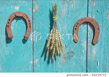 wheat bunch and two horseshoe luck symbol on wall 40259735