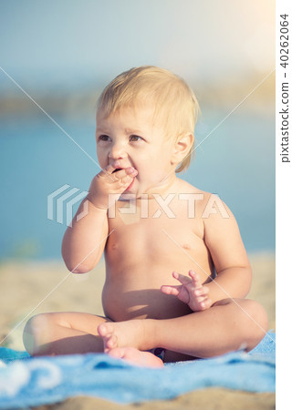 Cute baby playing with toys on sandy beach near the sea. Cute baby playing with toys on sandy beach near the sea. 40262064