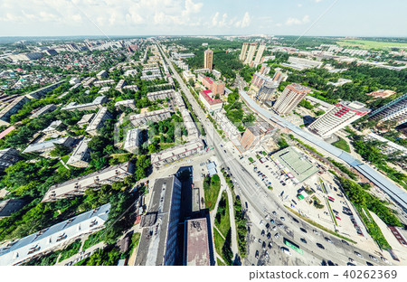 Aerial city view with crossroads and roads, houses, buildings, parks and parking lots. Sunny summer 40262369