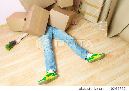 Picture of man in jeans lying under cardboard boxes 40264212