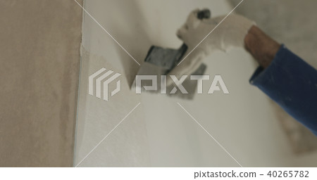 worker applying putty on the wall 40265782