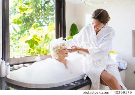Mother washing baby in bubble bath. Water fun. 40269179