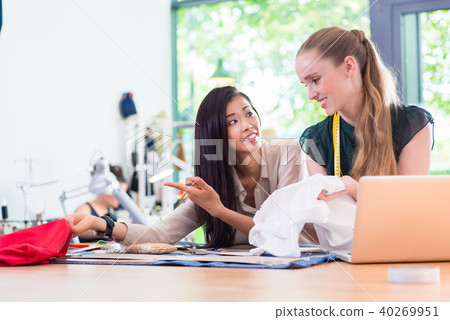 Young Fashion designer women measuring cloth  40269951