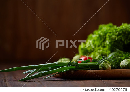 Vegetarian still life of fresh vegetables on wooden plate over rustic background, close-up, flat lay 40270976