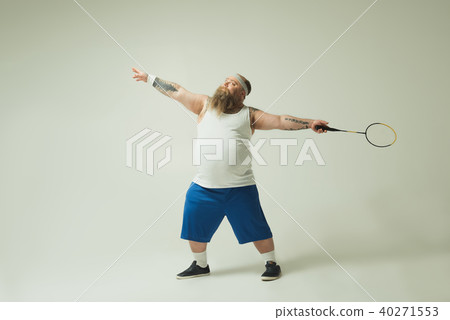 Sport thick guy entertaining with badminton racket 40271553