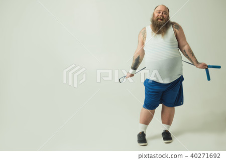 Sluggish fat man keeping skipping rope behind back 40271692