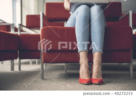 Female feet putting on fashionable footwear 40272253