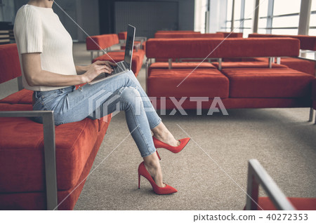 Lady typing in laptop on couch 40272353