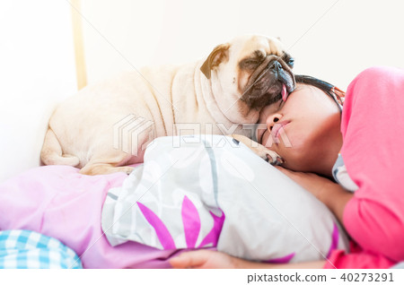 Asian Woman and her puppy pug dog sleep in the bed 40273291