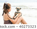 Girl playing with pug dog on the beach 40273323