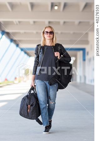 Portrait of young cheerful female traveler wearing casual clothes carrying heavy backpack and Portrait of young cheerful female traveler wearing casual clothes carrying heavy backpack and 40276503