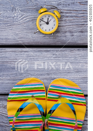 Flat lay, yellow flip-flops and clock. 40280805