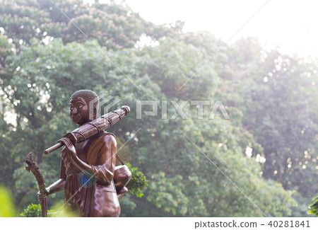 Statue monk of buddha standing on tree background Statue monk of buddha standing on tree background 40281841