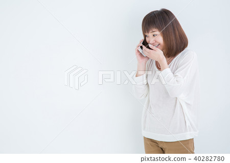 一個女人在電話裡咧著嘴笑 一個女人在電話裡咧著嘴笑 40282780
