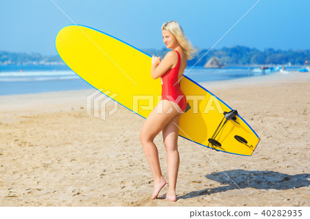 surf girl in red swimsuit holding a surfboard surf girl in red swimsuit holding a surfboard 40282935