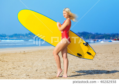 surf girl in red swimsuit holding a surfboard 40282938