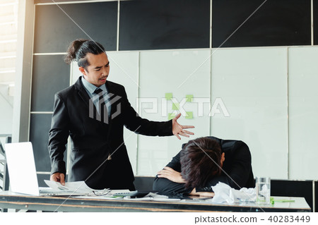 Manager reprimanding an employee in an office 40283449