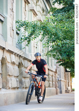Concerned male cyclist riding in urban area 40283467