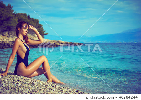 slim attractive woman posing in blue waters of Adriatic sea beac slim attractive woman posing in blue waters of Adriatic sea beac 40284244