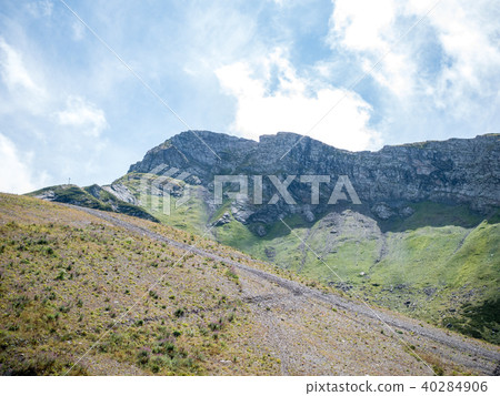 Photo of mountain slopes with vegetation and cloudy sky Photo of mountain slopes with vegetation and cloudy sky 40284906
