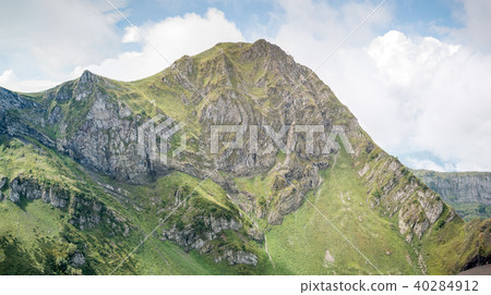 Photo of mountain slopes with vegetation and cloudy sky Photo of mountain slopes with vegetation and cloudy sky 40284912
