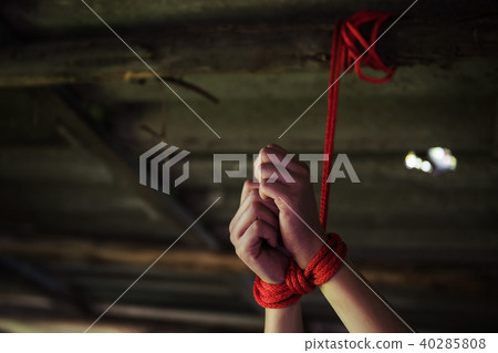Closeup hostage hands tied by red rope 40285808