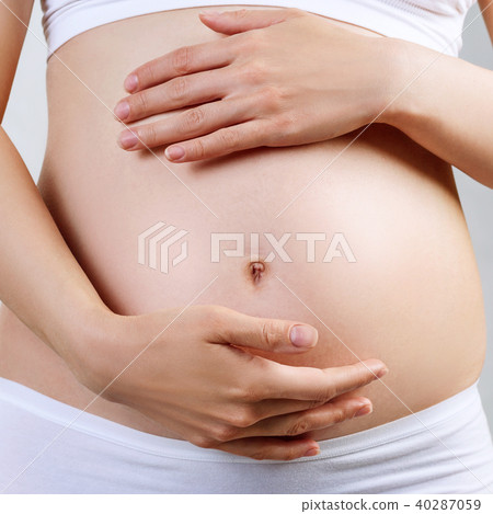 Young pregnant woman caress belly. 40287059