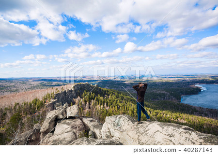 Young man standing on the top of the rock. 40287143