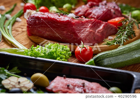 Still life of raw beef meat with vegetables on wooden plate over vintage background, top view 40290596