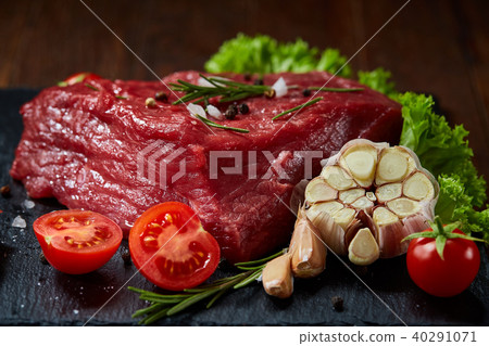 Composition of raw beefsteak on slate board with vegetables and seasoning, selective focus, close-up 40291071