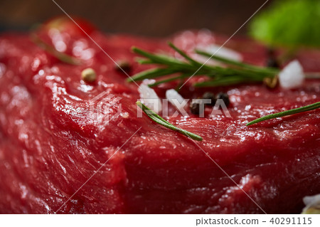 Composition of raw beefsteak on slate board with vegetables and seasoning, selective focus, close-up 40291115