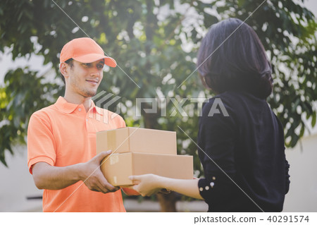 Delivery man in orange handing packages to a woman 40291574