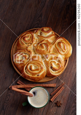 Creamy coffee in cup with homemade rose bread on vintage wooden background, close-up, selective Creamy coffee in cup with homemade rose bread on vintage wooden background, close-up, selective 40294260