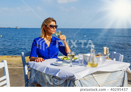 Young woman in a restaurant by the sea Young woman in a restaurant by the sea 40295437