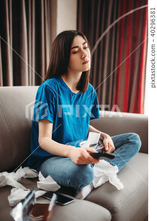 Stressed woman sitting on couch and eats chocolate 40296381