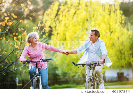 Beautiful senior couple with bicycles outside in spring nature. Beautiful senior couple with bicycles outside in spring nature. 40297874