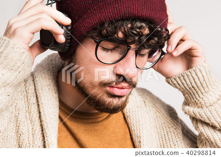 Portrait of a young man with hat and headphones in a studio. Portrait of a young man with hat and headphones in a studio. 40298814