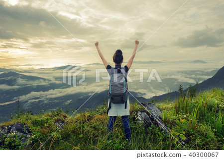 woman tourists arms up on the hill 40300067