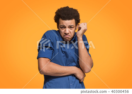 Let me think. Doubtful pensive man with thoughtful expression making choice against orange Let me think. Doubtful pensive man with thoughtful expression making choice against orange 40300456