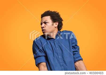 Let me think. Doubtful pensive man with thoughtful expression making choice against orange 40300483