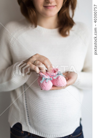 child fashion, pregnancy, expectation concept. close up of decorative baby bootees in delicate arms child fashion, pregnancy, expectation concept. close up of decorative baby bootees in delicate arms 40300757