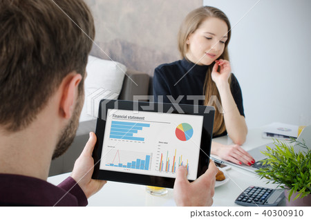 Businessman working on tablet. Couple at home. 40300910