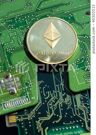 Golden ethereum coin lying on computer motherboard 40303515